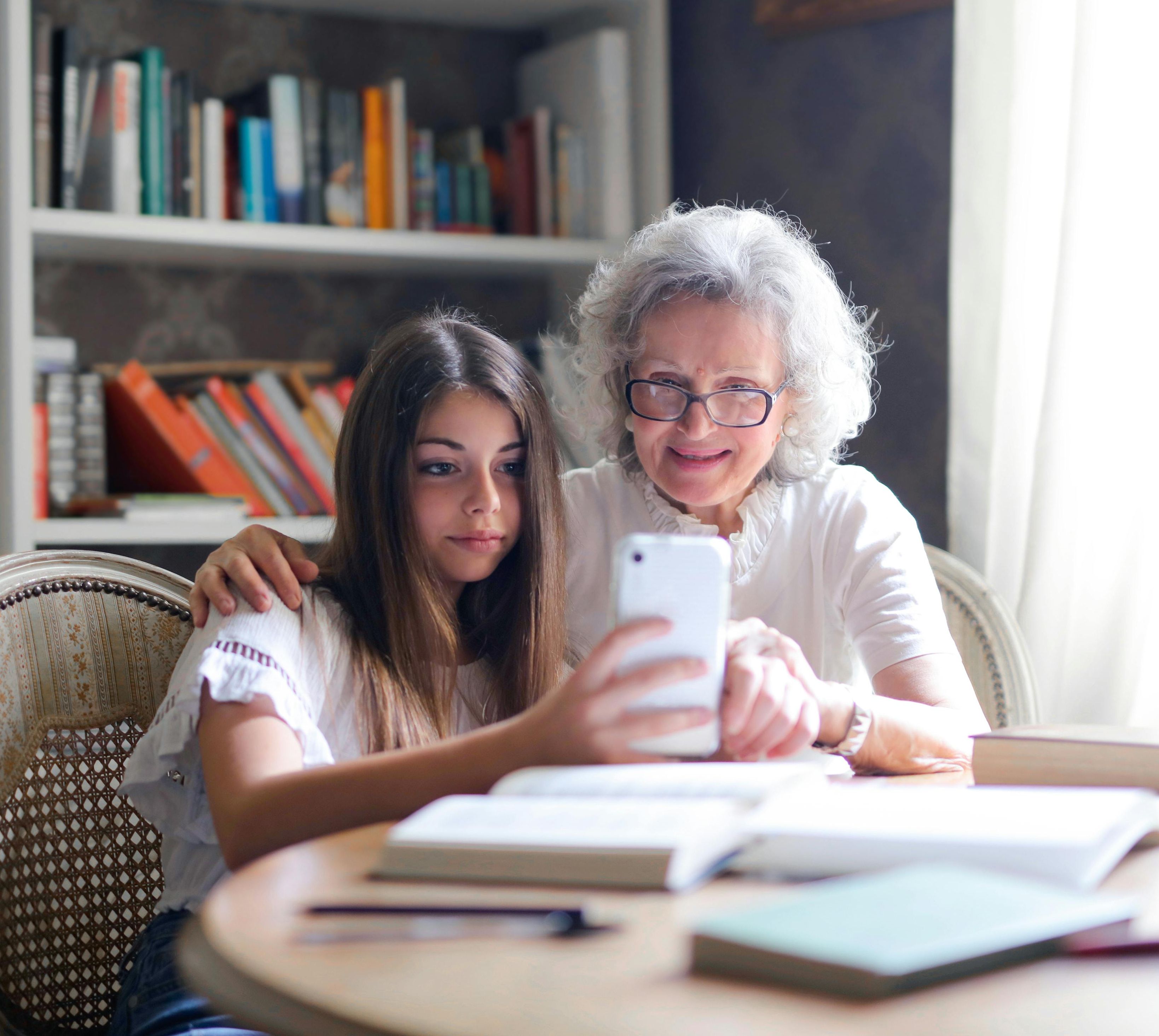 teenager showing grandma how to use an app