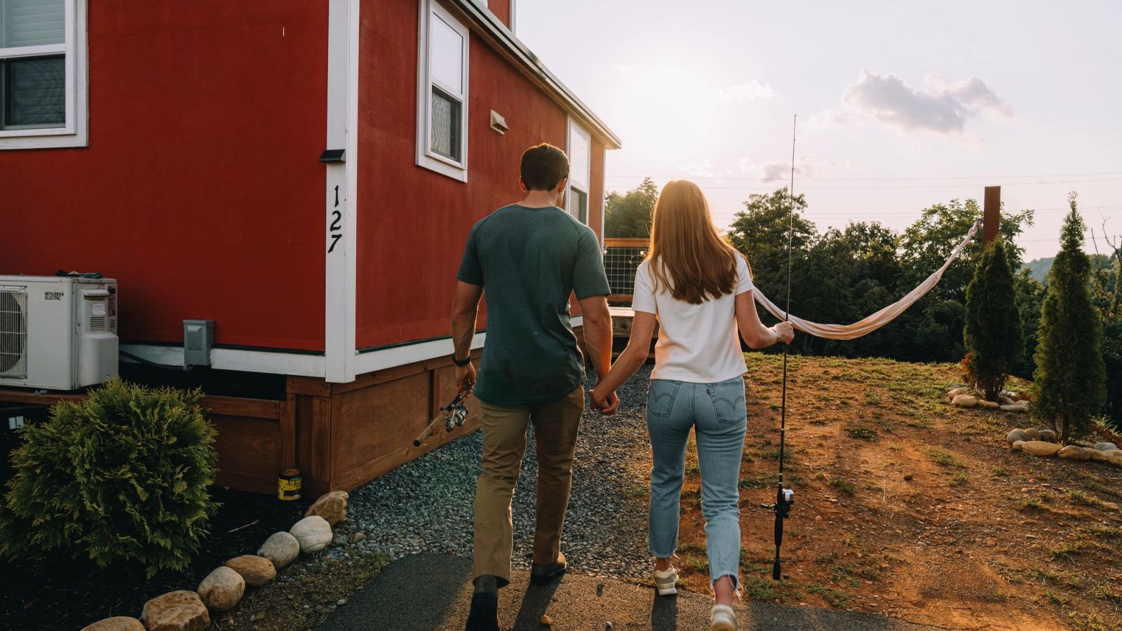 A couple walking together across the grounds at Sojourn Lodging in the evening light