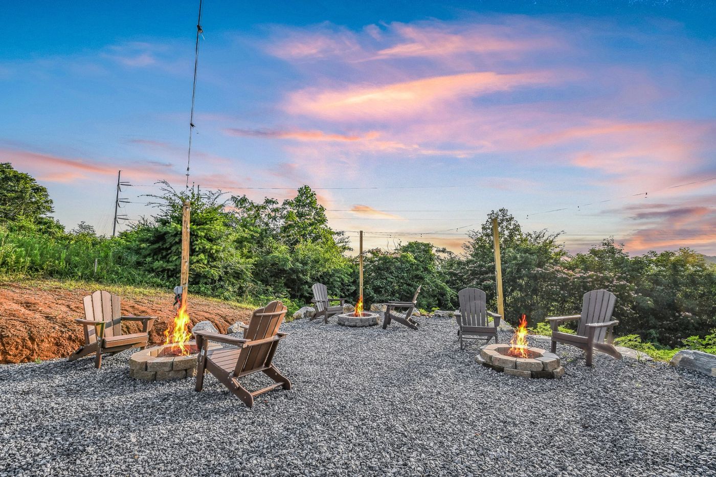 Guests with drinks beside a community firepit at Sunset Point in the evening