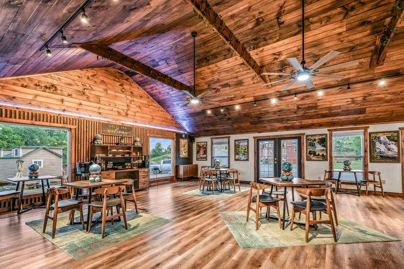 Cookout Zone pavilion with built-in grill station and picnic tables at Sojourn Lodging with tiny homes and mountains in background