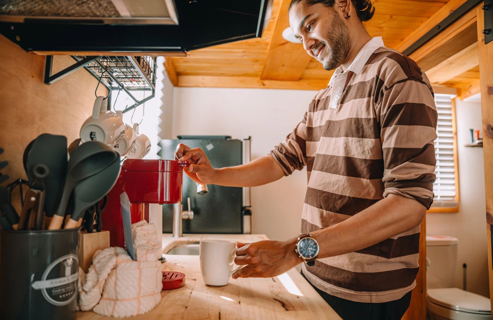 A guest brewing coffee in the kitchenette of his tiny home at Sojourn Lodging