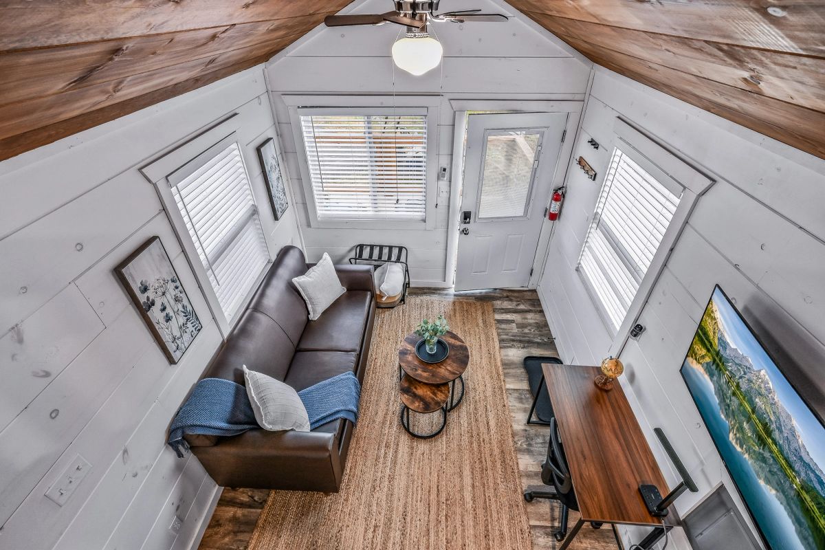 Bird's-eye view from the sleeping loft of a Sojourn tiny home showing the full living space below