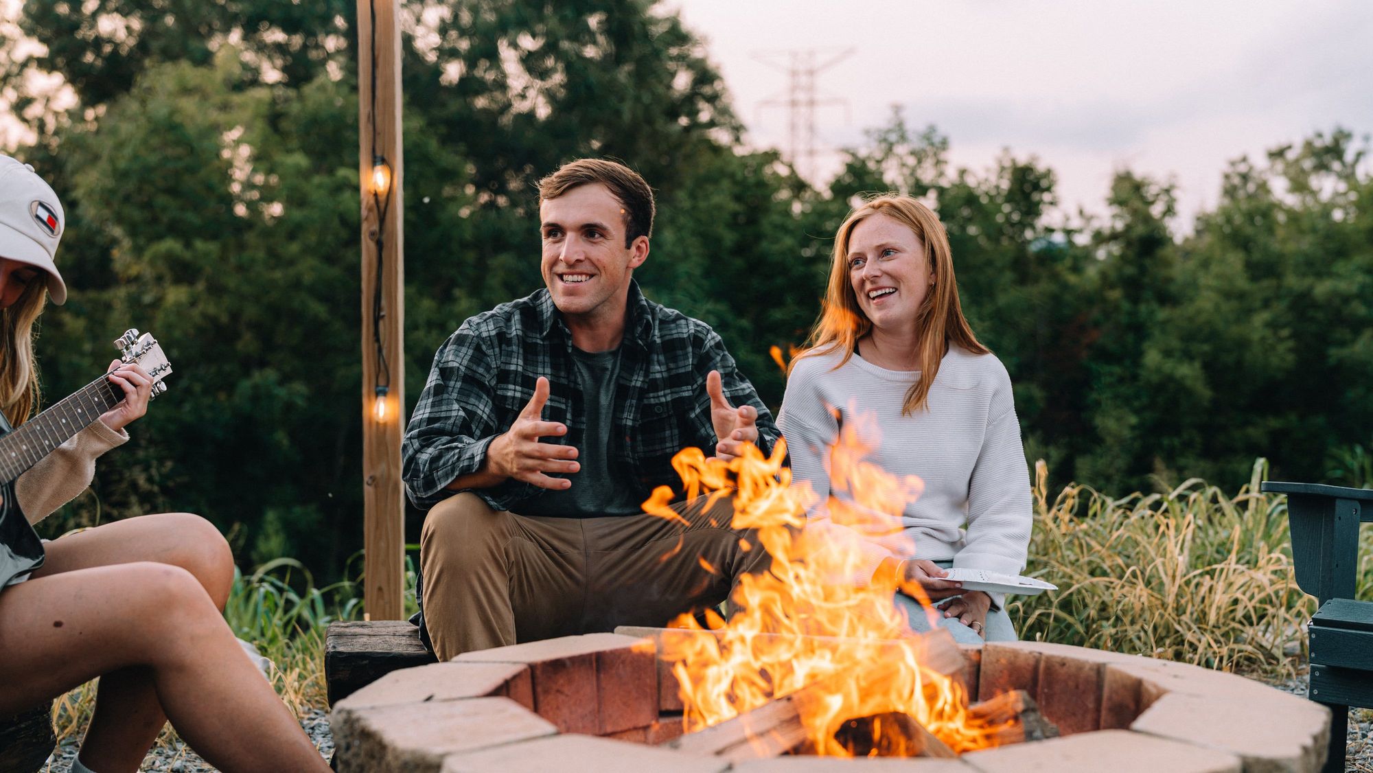 Friends talking around the Sunset Point firepit in the evening light at Sojourn Lodging