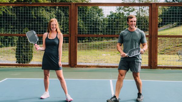 Two players in ready position on the pickleball court at Sojourn Lodging