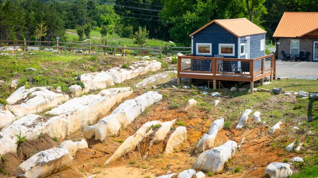 Aerial drone view of Sojourn Lodging's 11-acre property with illuminated limestone formations and Smoky Mountain surroundings