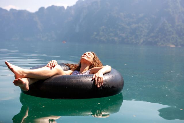 Woman tubing with a mountain background.