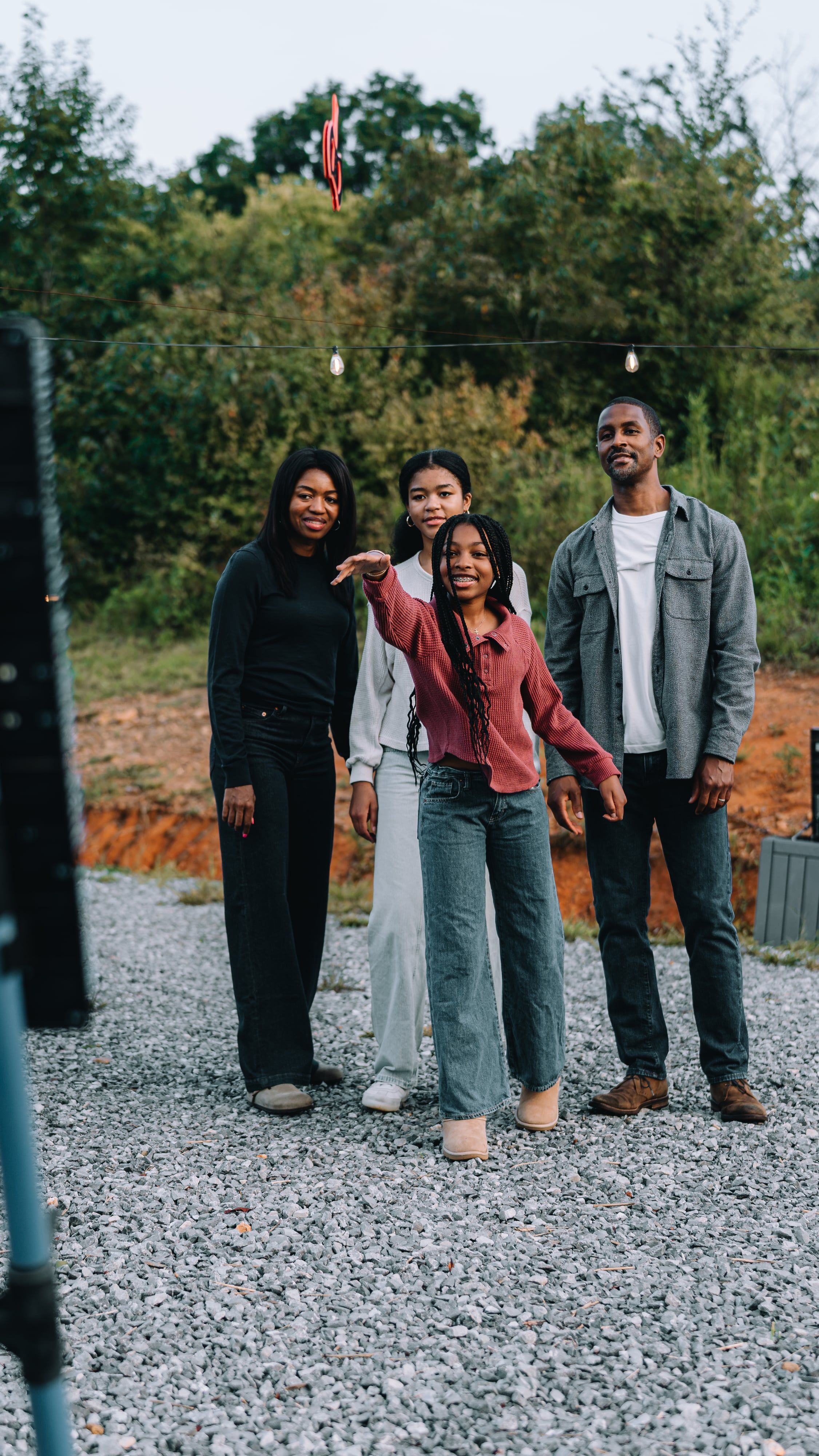 Four friends standing on the gravel beside the axe-throwing lane at Sojourn Lodging