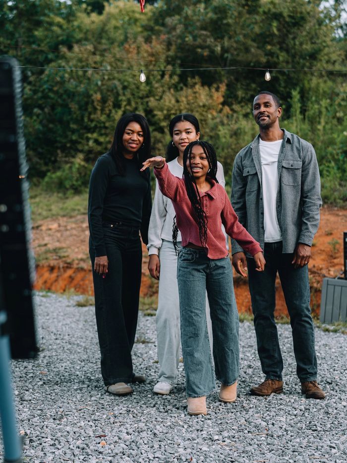 Four friends standing on the gravel beside the axe-throwing lane at Sojourn Lodging
