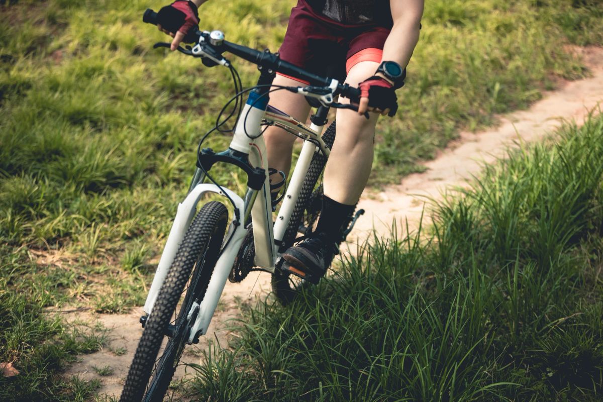 Woman mountain biking on a paved path.