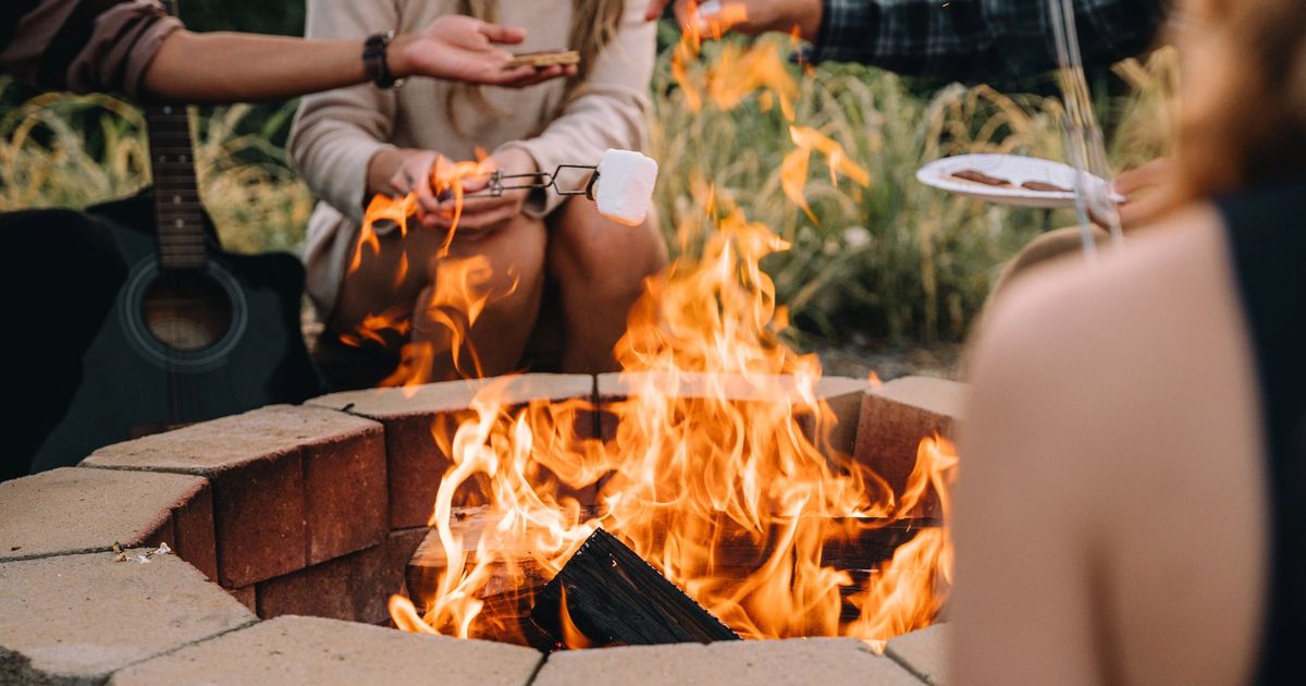 The Sunset Point firepit burning with a guitar propped alongside at Sojourn Lodging