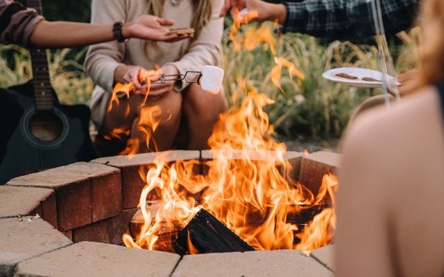 The Sunset Point firepit burning with a guitar propped alongside at Sojourn Lodging