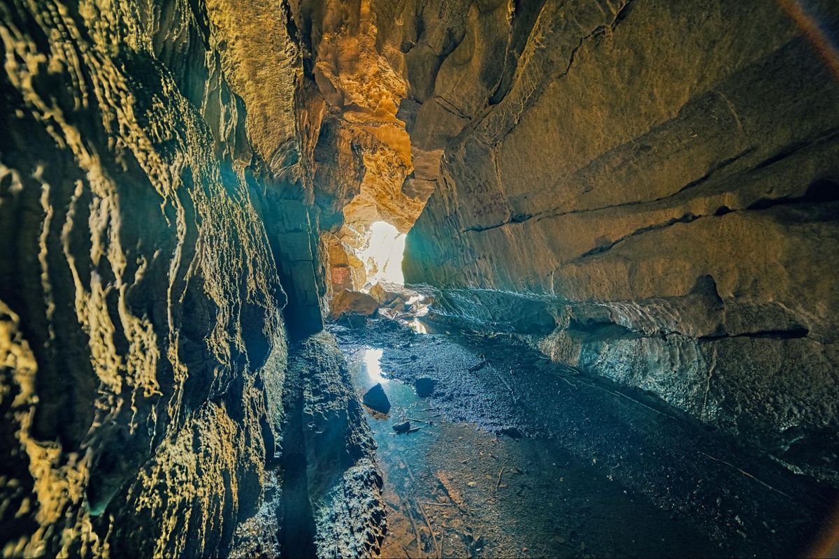 Glowing cave interior with light streaming through the tunnel at Sojourn's grotto in Sevierville, TN