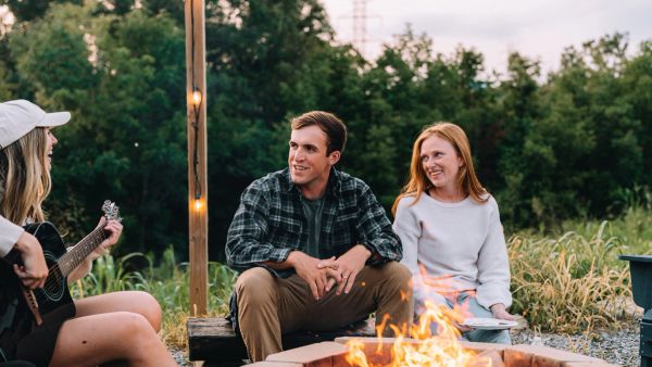 Friends listening to guitar around the Sunset Point firepit at Sojourn Lodging