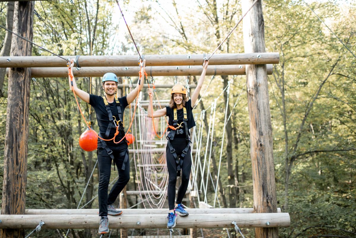 Man and woman standing by zipline.