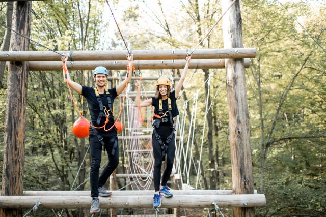 Man and woman standing by zipline.