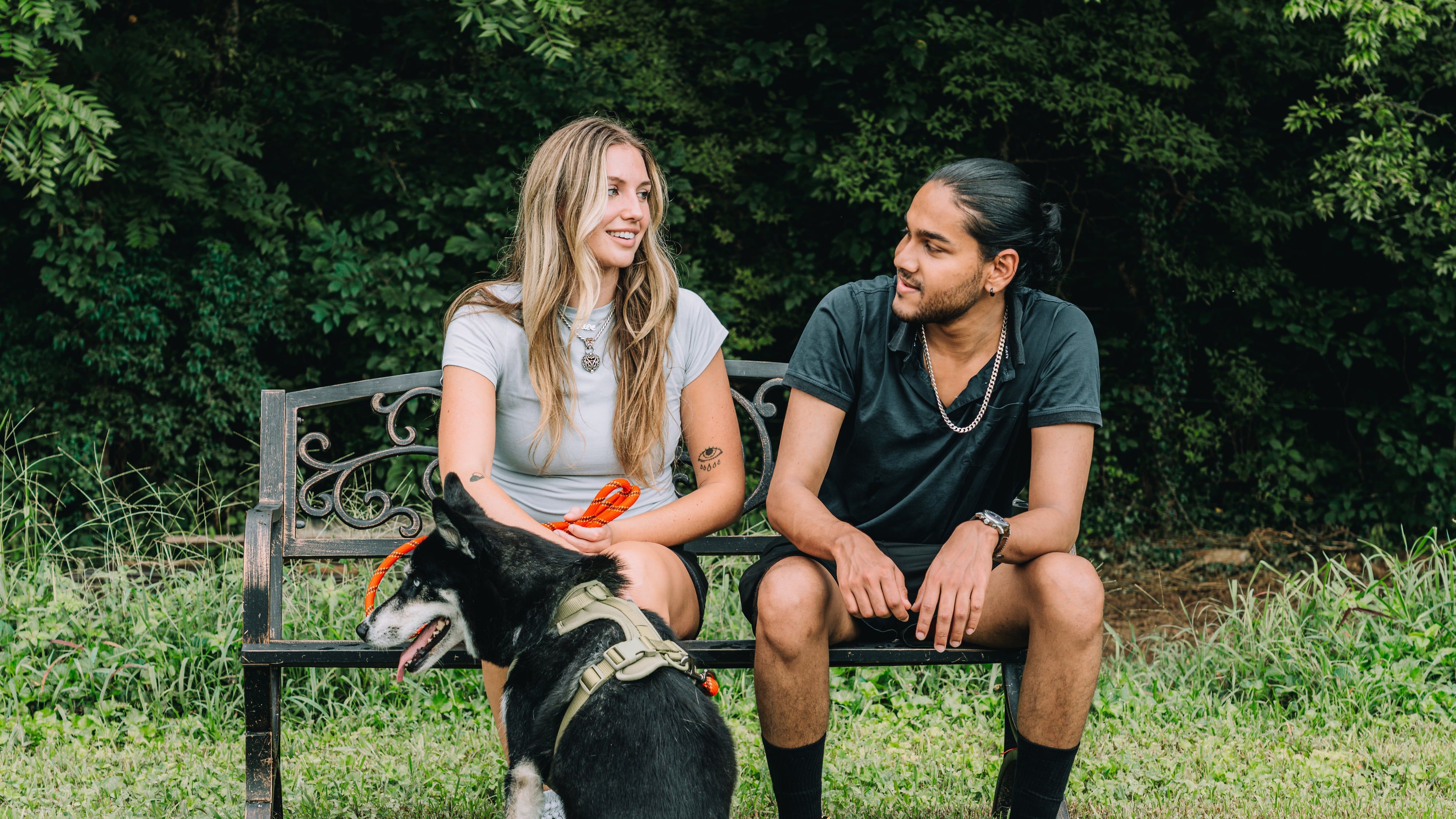 A couple sitting on a trailside bench with their dog at Sojourn Lodging