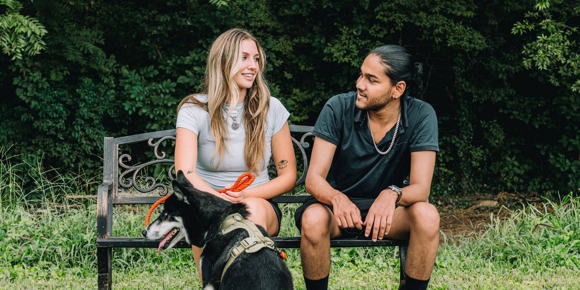 A couple sitting on a trailside bench with their dog at Sojourn Lodging