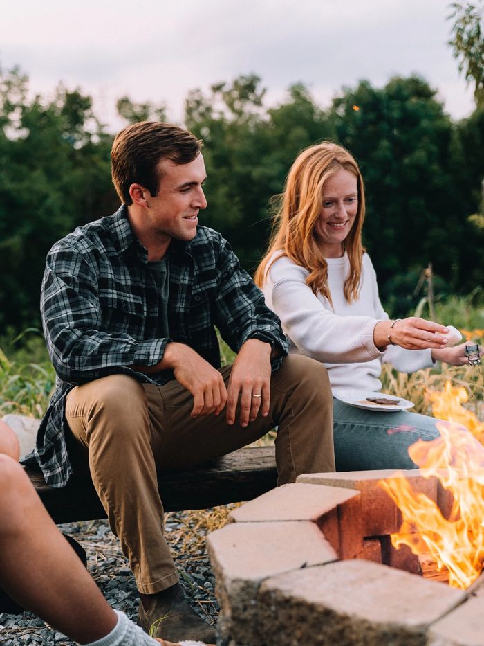 A couple sitting close together beside the Sunset Point firepit at Sojourn Lodging