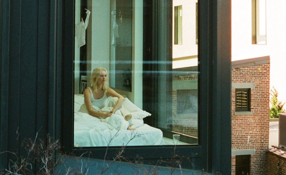 three framed photography prints depicting a NYC apartment building, white go-go boots, and a bottle of wine and empty wine glass in a tub. All displayed on a wall in a pub.