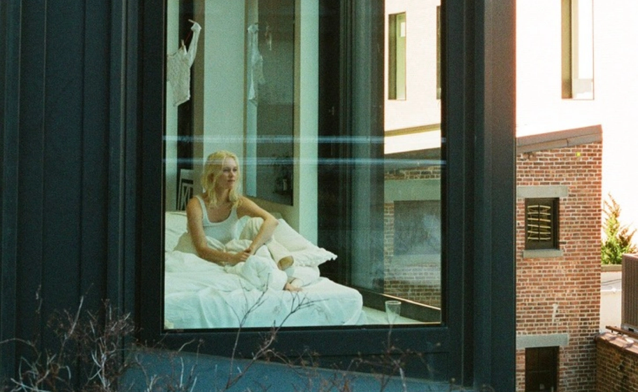 three framed photography prints depicting a NYC apartment building, white go-go boots, and a bottle of wine and empty wine glass in a tub. All displayed on a wall in a pub.