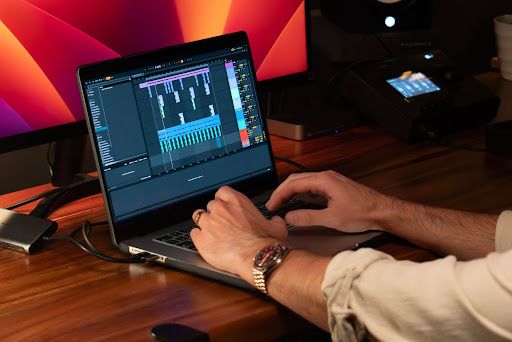 An artist mixing a song on his laptop