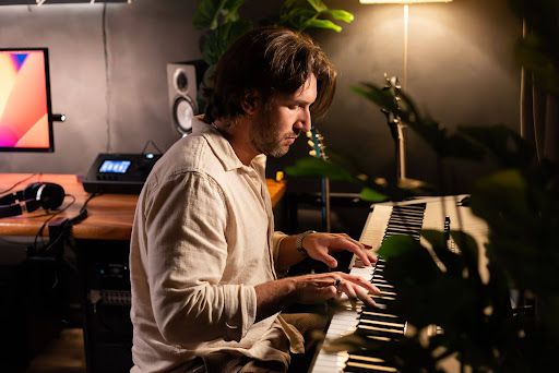An artist composing music on a piano keyboard