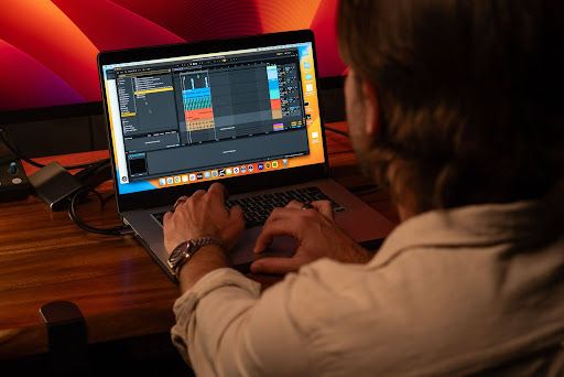 An artist editing music on his laptop