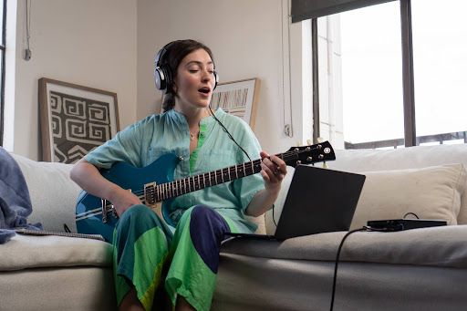 An artist playing guitar and singing