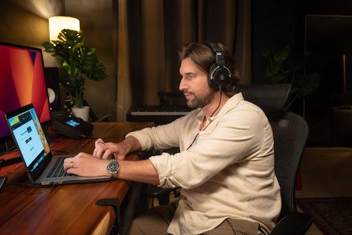 An artist mixing music on a laptop