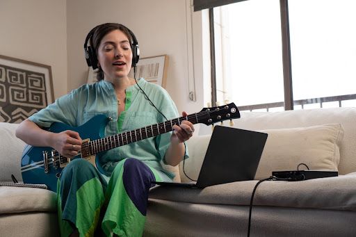 A musician singing while playing guitar