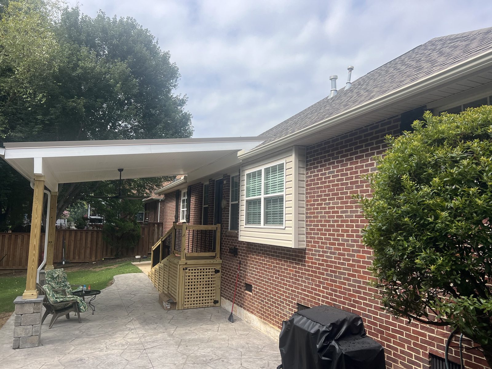 Covered patio and paver seating area on a brick home