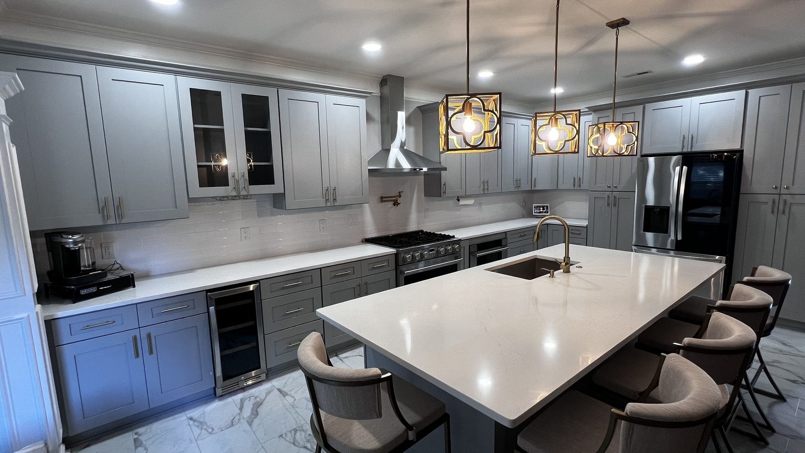 Gray shaker kitchen with quartz waterfall island and bar seating