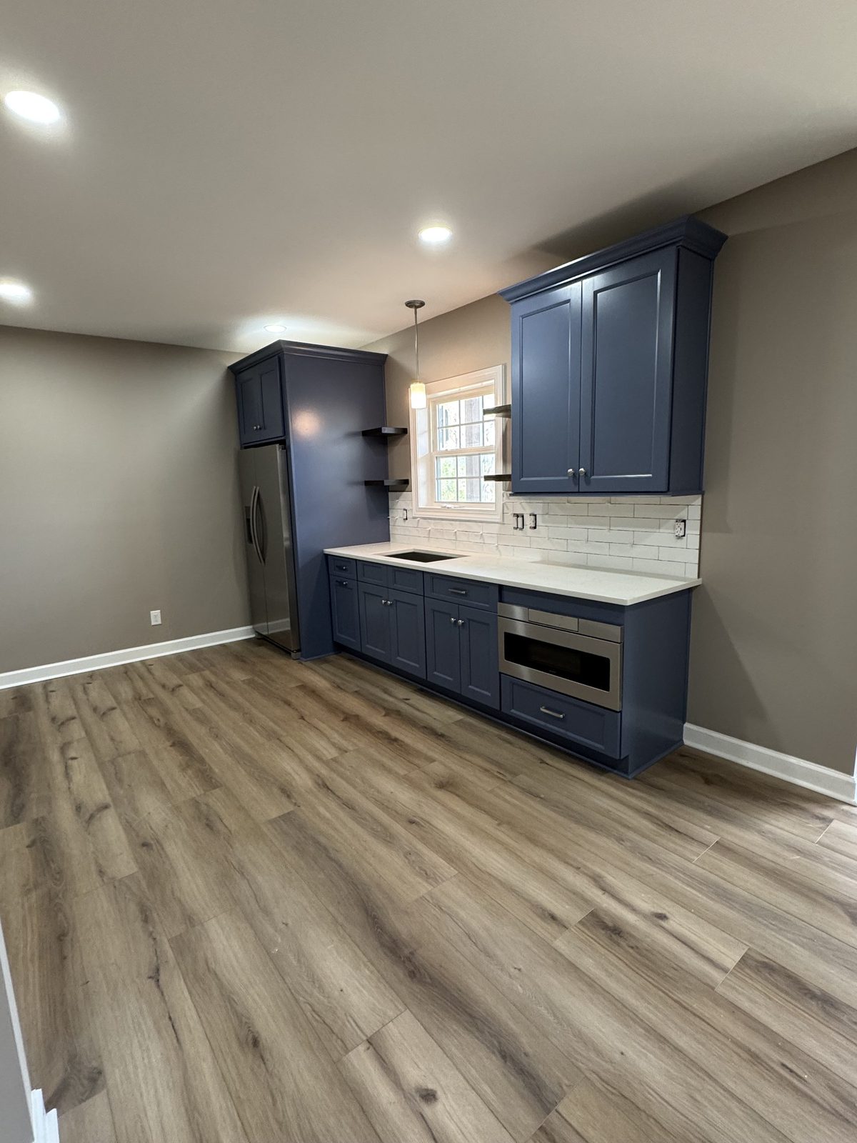 Basement kitchenette with navy cabinets and quartz counter