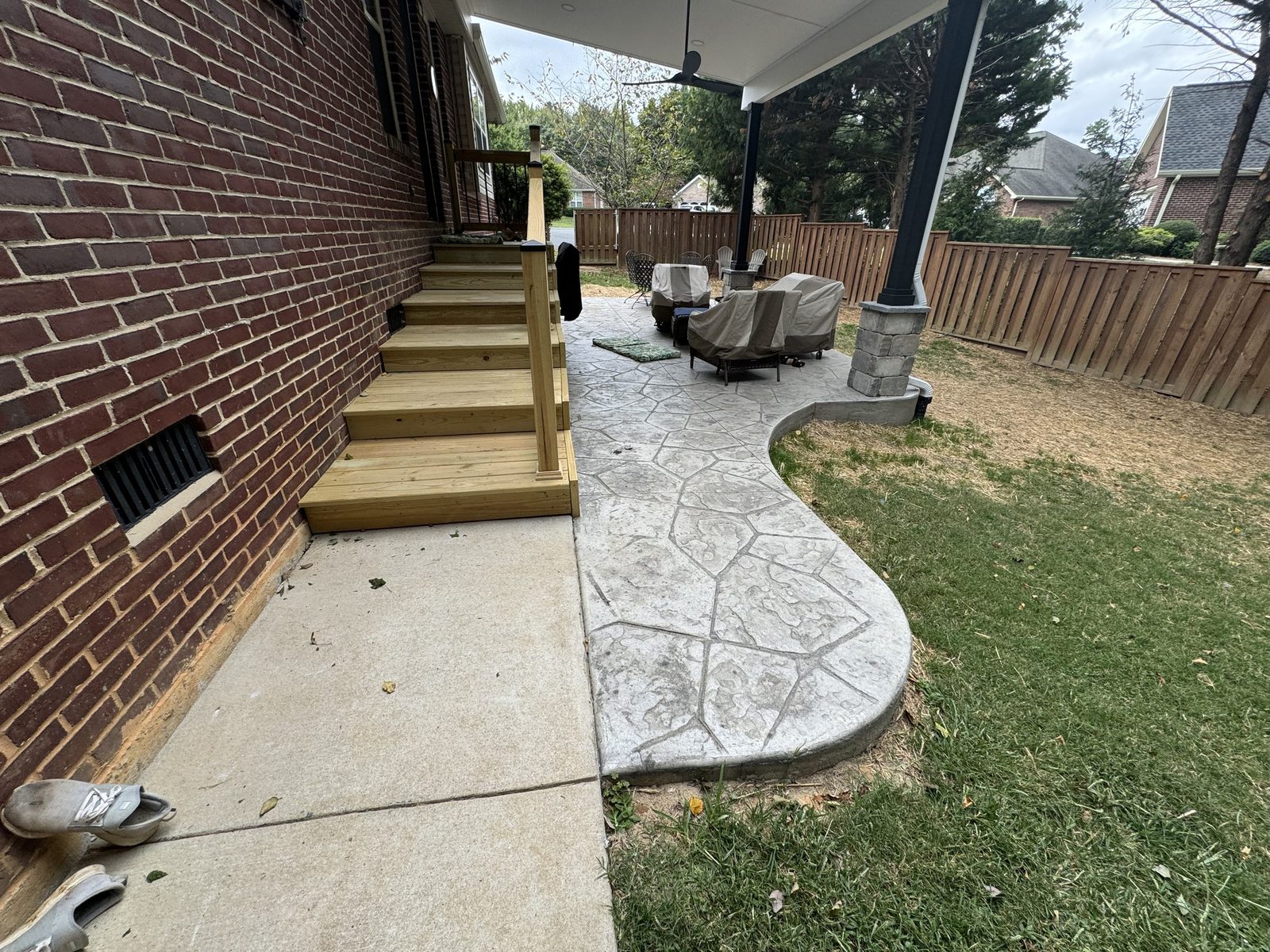 Stamped concrete patio behind a brick home