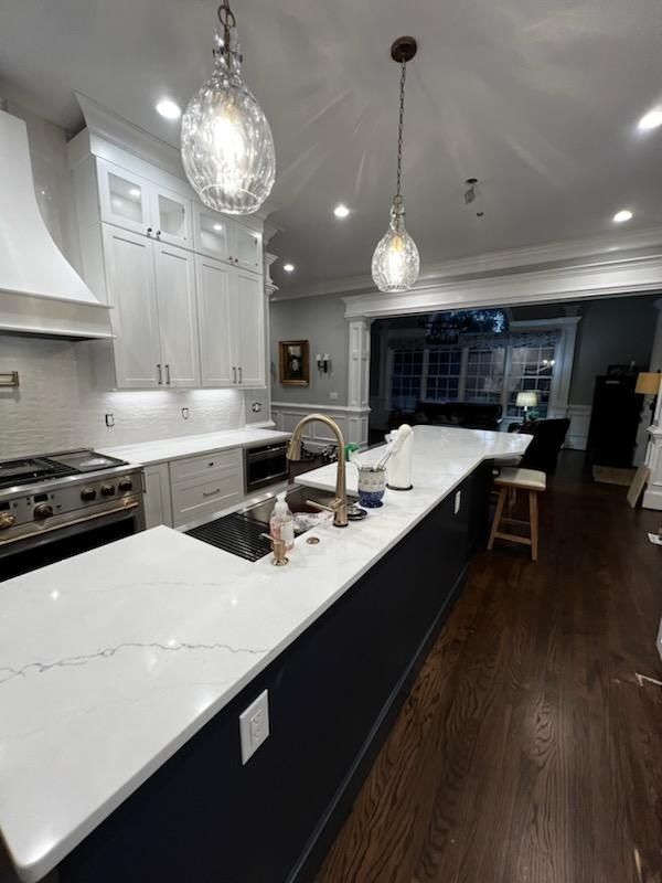 Modern kitchen with white waterfall island and pendant lighting