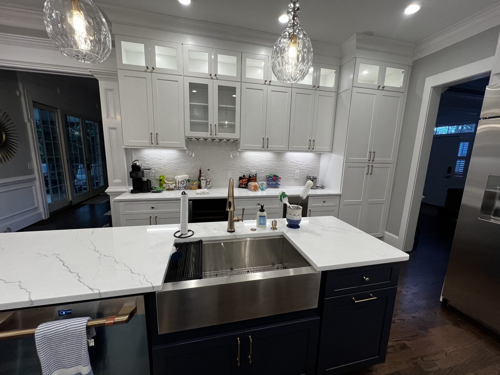 White kitchen with farmhouse sink and marble waterfall island