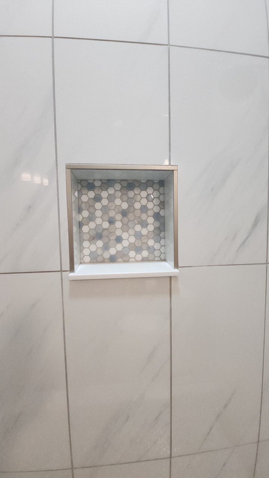 Custom tile shower niche with mosaic accent