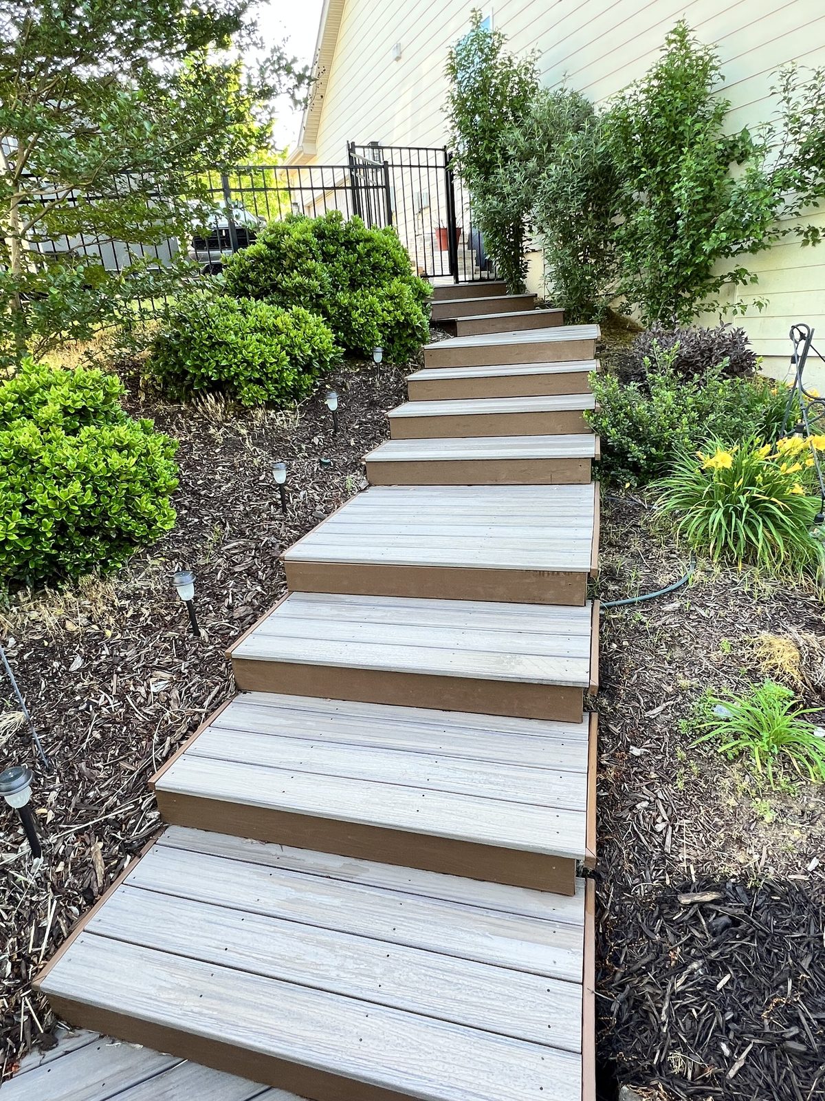 Composite walkway through a landscaped backyard