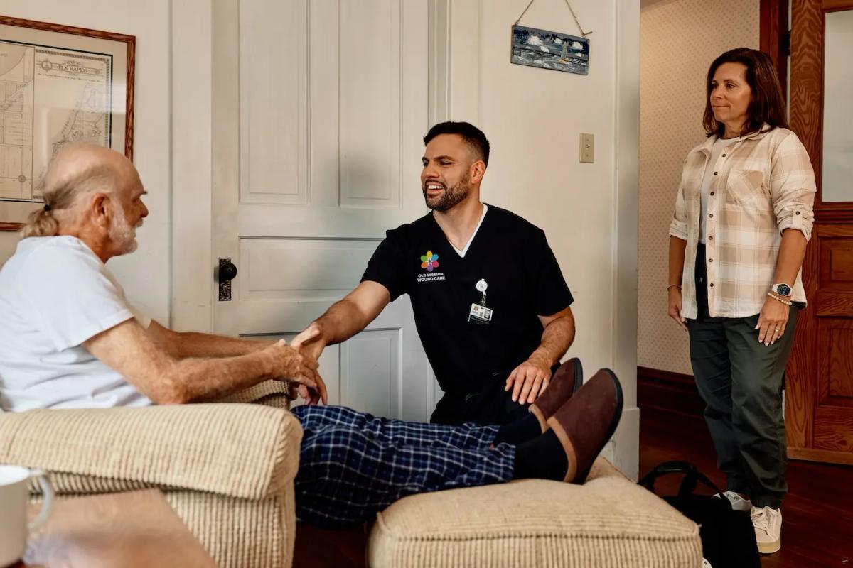 An Old Mission Wound Care nurse practitioner greets a wound care patient in his home.