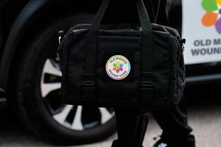 A mobile nurse practitioner carries an Old Mission Wound Care medical bag to an appointment.