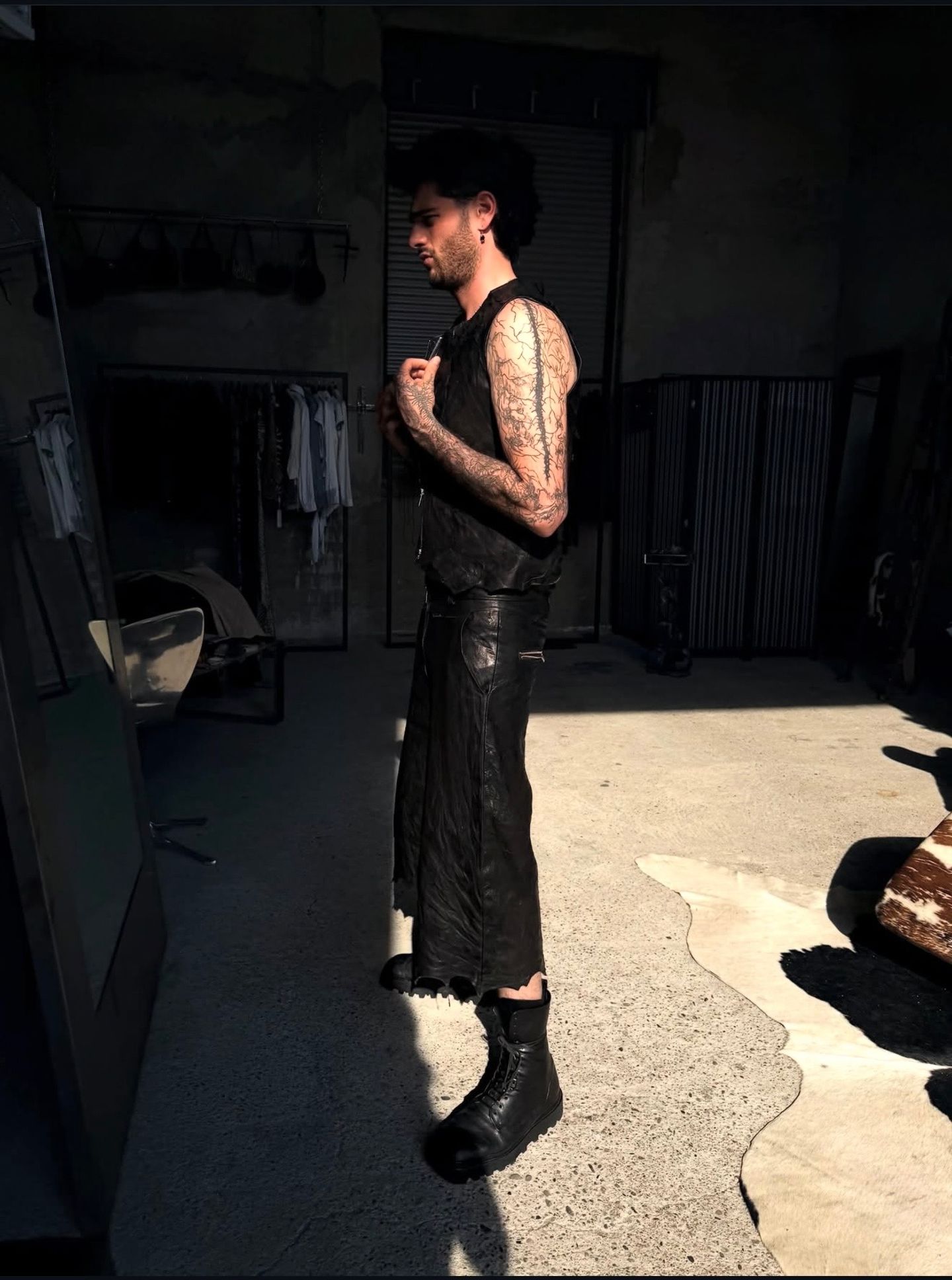 Gli stessi pantaloncini indossati, di profilo, con gli stivali.