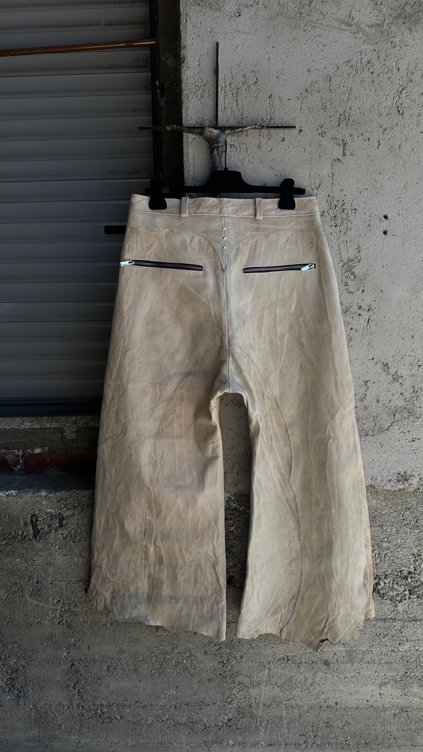 Il retro degli stessi pantaloni chiari, con due tasche con zip.
