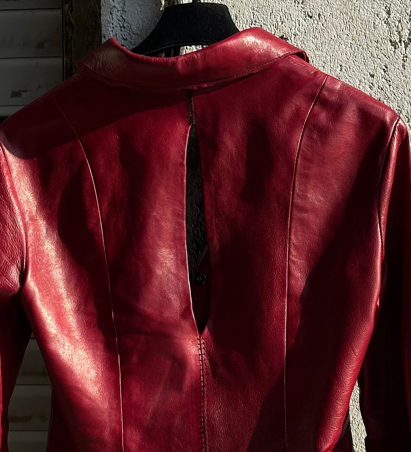 Apertura a mandorla sulla schiena della giacca rossa, tra le cuciture verticali.