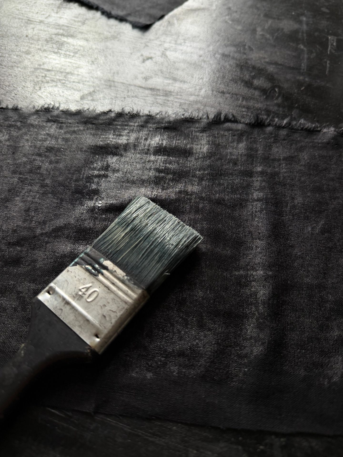 Pennello largo appoggiato su una pelle appena tinta di scuro.