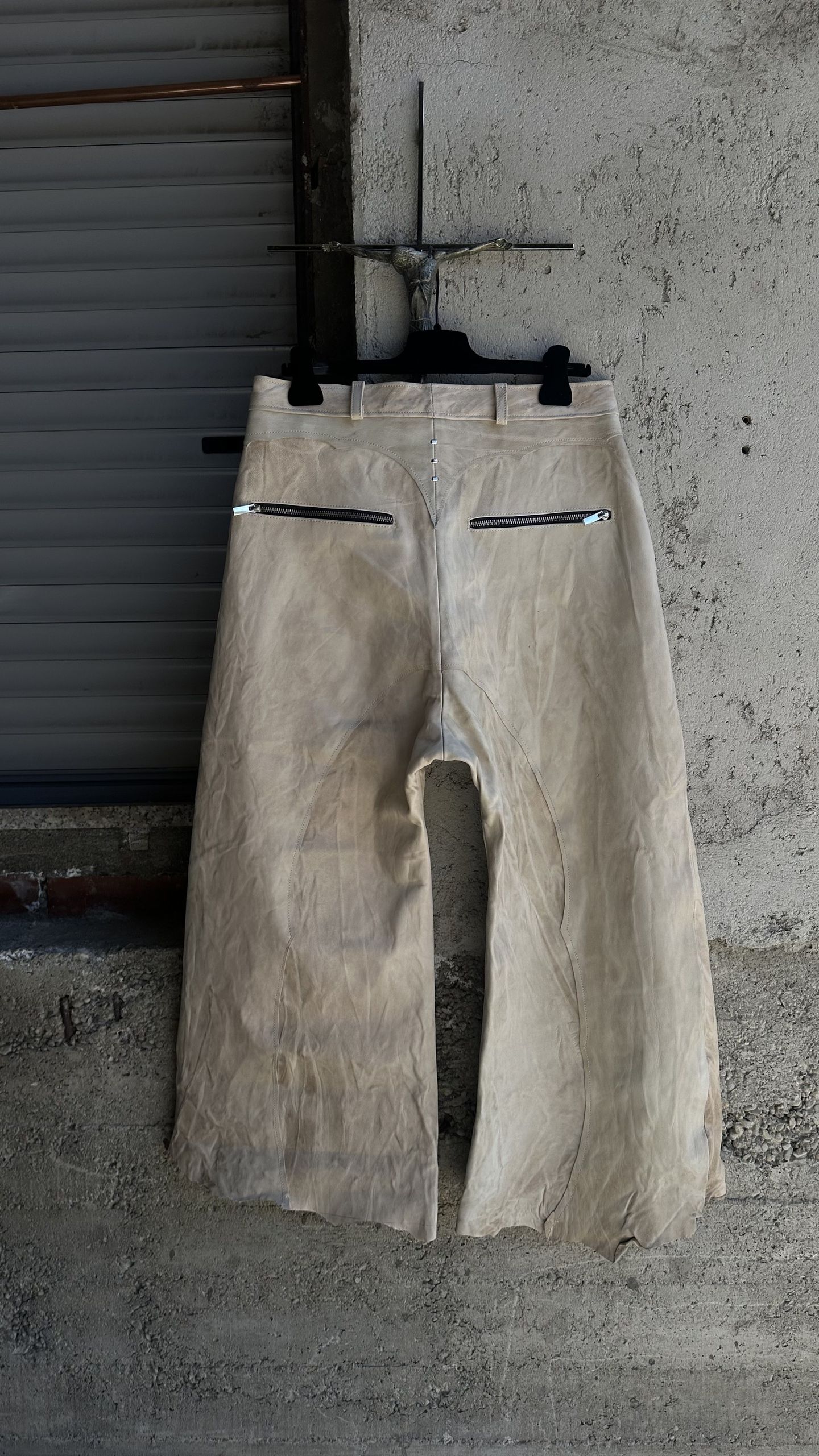 Gli stessi pantaloni chiari visti da dietro, con due tasche con zip sul retro.