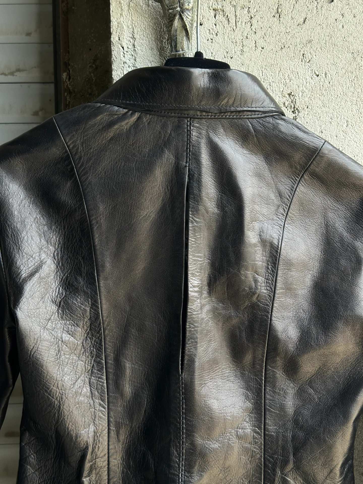 Fronte della camicia in pelle nera, con la fila di bottoni automatici.