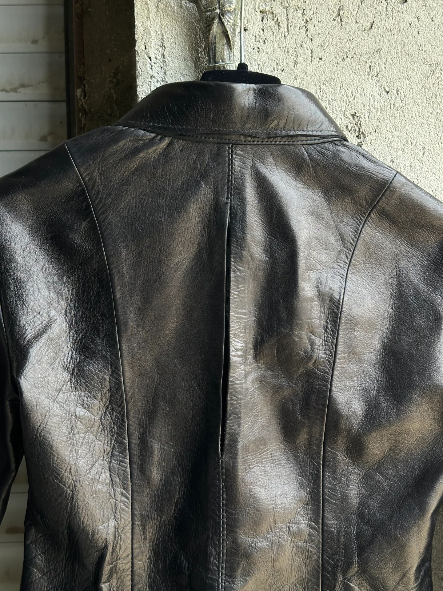 Fronte della camicia in pelle nera, con la fila di bottoni automatici.