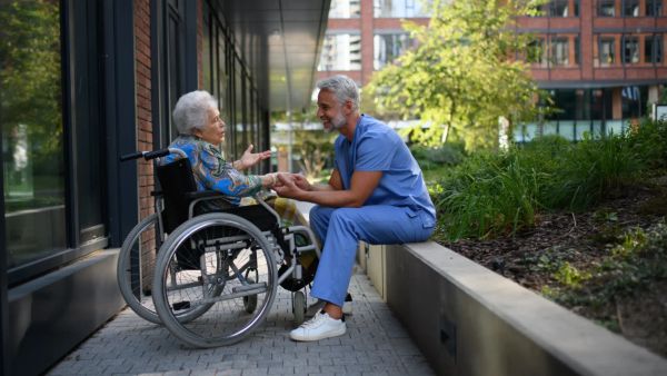 Carer talking with elderly woman in wheelchair about end-of-life care in Melbourne