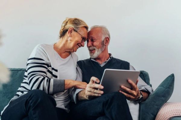 Older Melbourne couple reviewing retirement planning options on a tablet at home