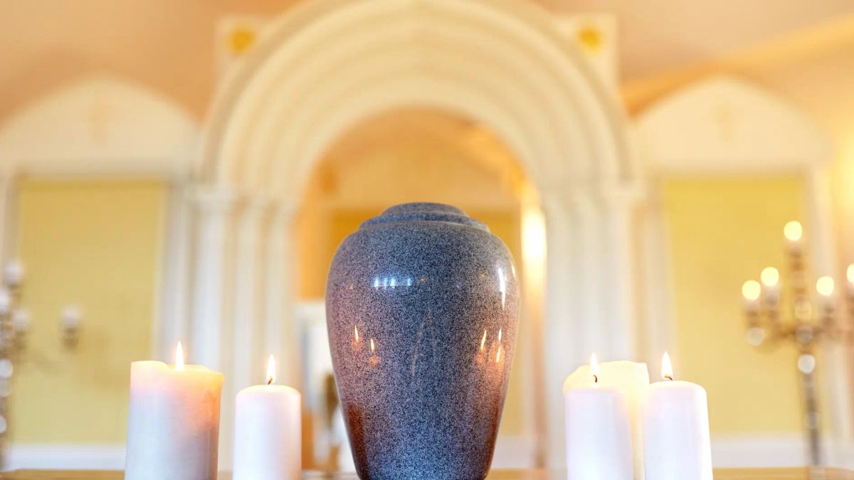 Granite cremation urn surrounded by lit candles in a memorial chapel